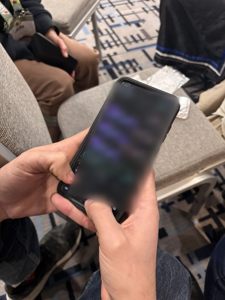 Unas manos sosteniendo un tel&eacute;fono con la aplicaci&oacute;n de mensajes de la malla abierta, con la pantalla difuminada