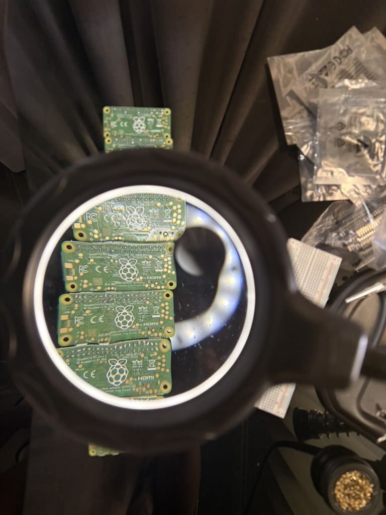 Cuatro placas Raspberry Pi Zero vistas a trav&eacute;s de una lupa con luz de anillo