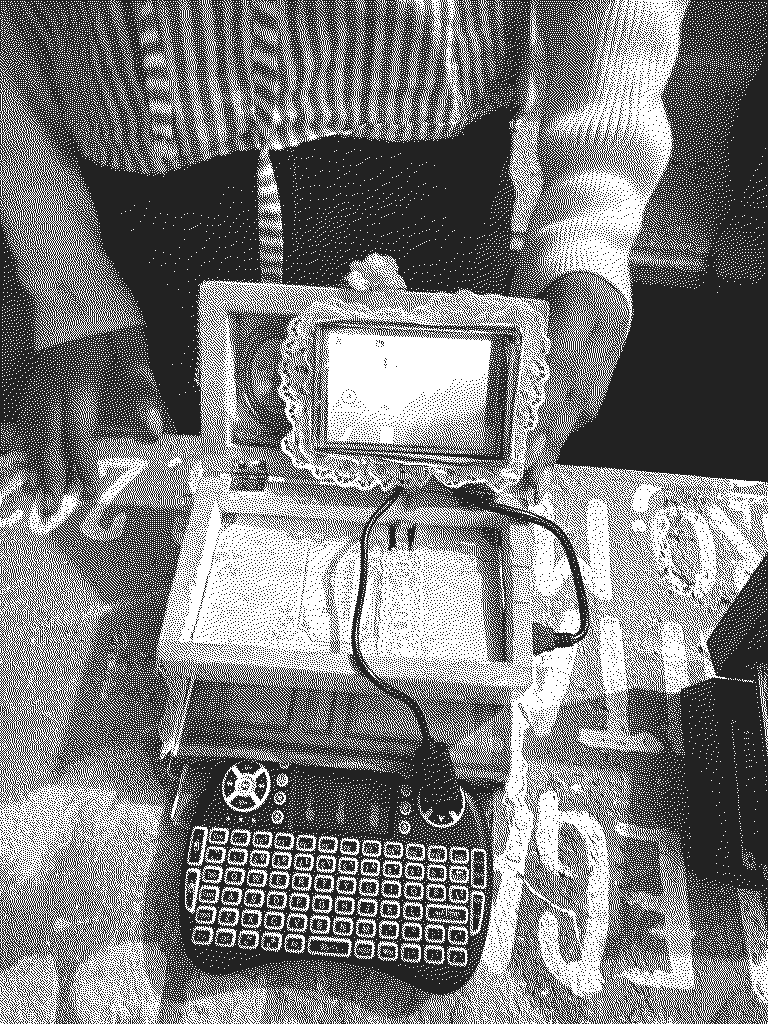 Una de las computadoras terminadas, abierta: una caja de madera forrada de encaje, con la pantalla encendida
