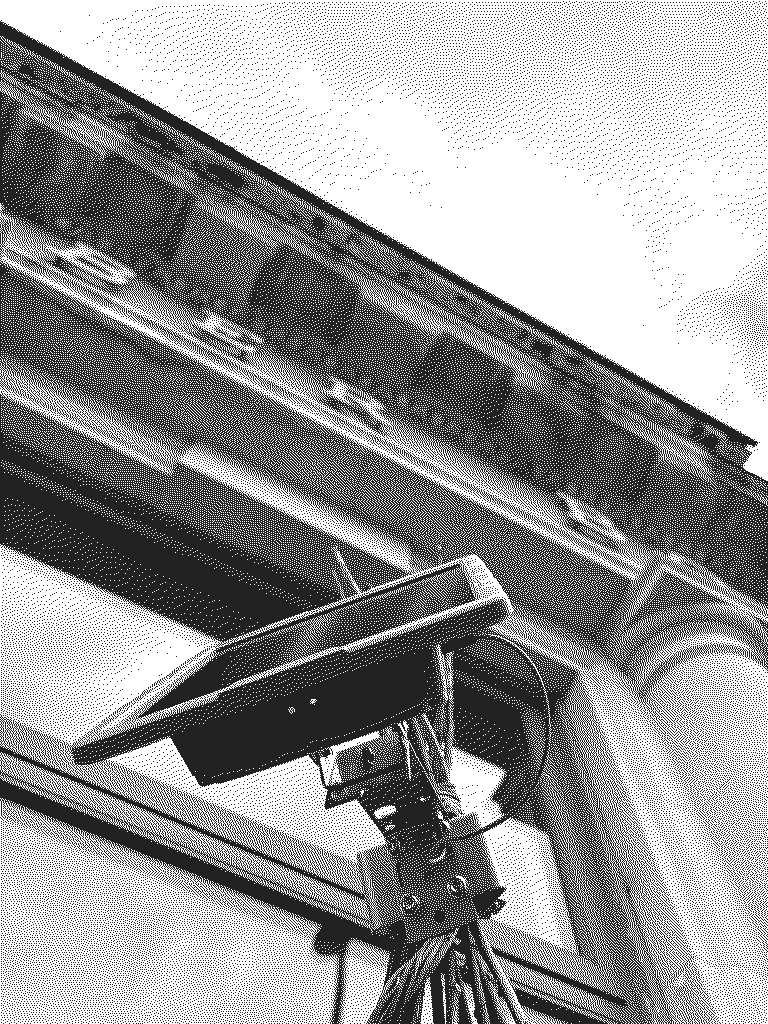 El nodo instalado en la fachada de October Books: un panel solar pequeño y una antena vistos desde abajo contra el cielo