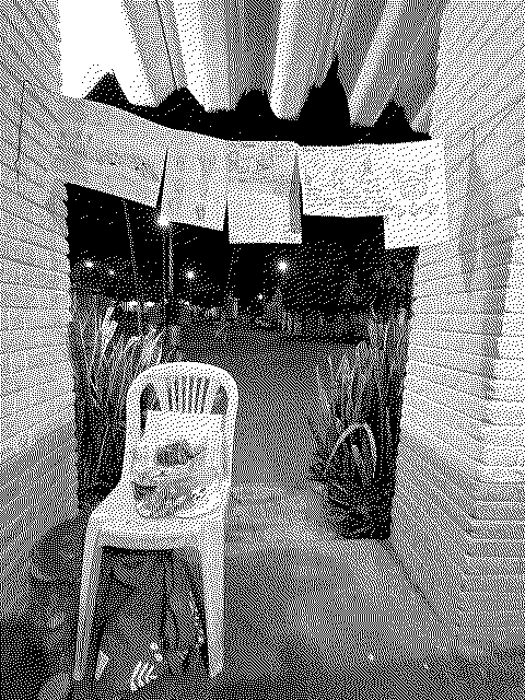 La entrada en arco de un espacio en Quebrantadero de noche, con dibujos colgados de un cordel y la calle al fondo